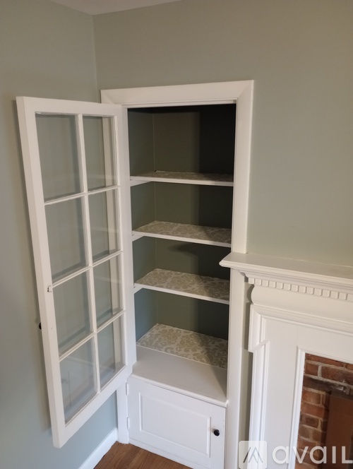 A white cabinet with glass doors and shelves.