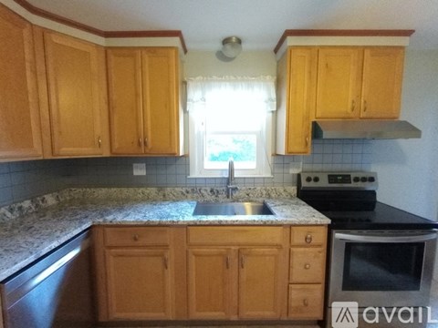 A kitchen with wooden cabinets and granite countertops.