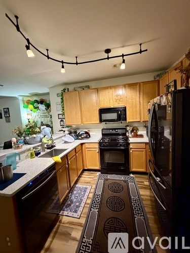 A kitchen with wooden cabinets and a black stove top oven.