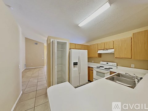 A kitchen with a refrigerator, stove, and sink.