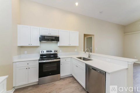 A kitchen with white cabinets and appliances is available for rent.