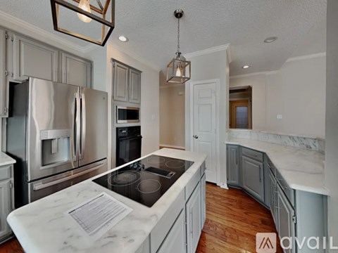 A kitchen with a marble countertop and stainless steel appliances.