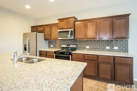 A kitchen with brown cabinets and a granite countertop.