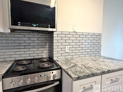 A kitchen with a stove and a microwave above it.