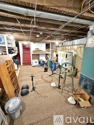 A room with a lot of clutter and a drum set.