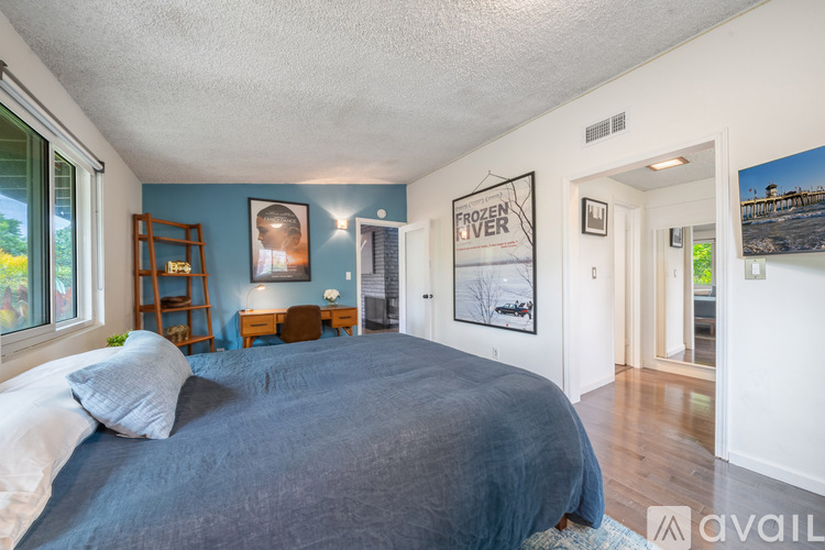 A bedroom with a large bed and a poster on the wall.