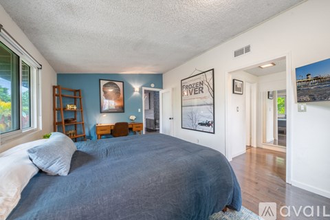 A bedroom with a large bed and a poster on the wall.