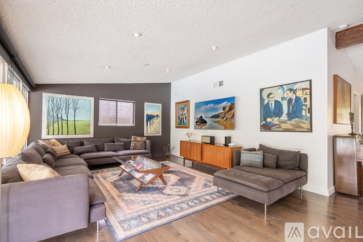 A living room with a grey couch and a brown coffee table.