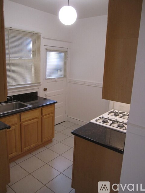 A kitchen with wooden cabinets and a black countertop.