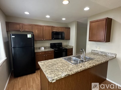 A kitchen with granite countertops and wooden cabinets.