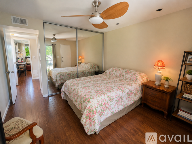 A bedroom with a large bed and a ceiling fan.