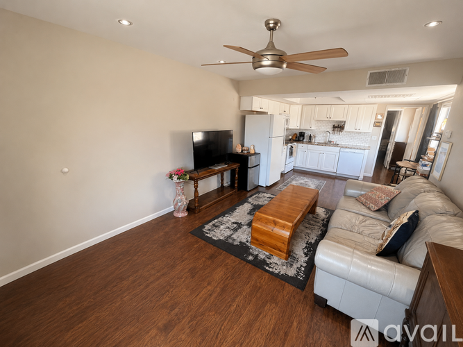 A living room with a couch, coffee table, and a ceiling fan.