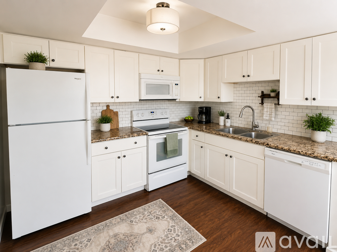 A kitchen with white appliances and cabinets.