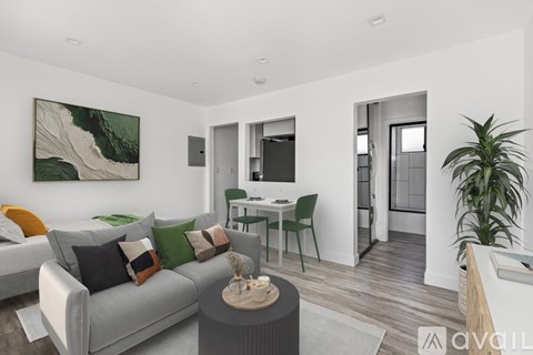 A living room with a grey couch, a green chair, a painting on the wall, and a wooden coffee table.