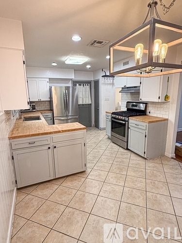 A kitchen with white cabinets and a tile floor.