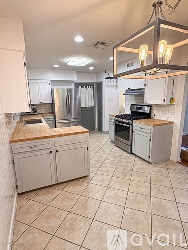 A kitchen with white cabinets and a tile floor.