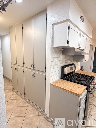 A kitchen with white cabinets and a wooden countertop.