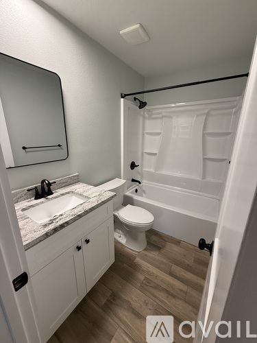 A bathroom with a sink, toilet, and bathtub.