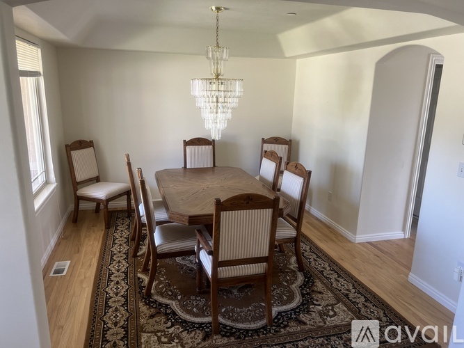 A dining room with a table and chairs.