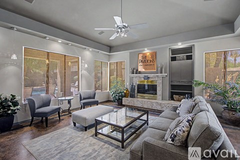 A living room with a grey couch and a fireplace.