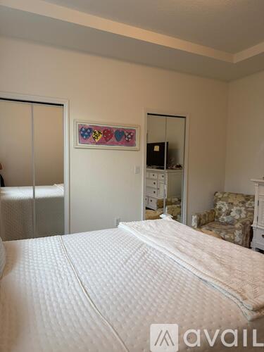 A bedroom with a large bed and a dresser with a mirror.