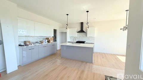 A kitchen with white cabinets and a grey island.