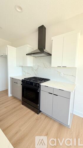 A kitchen with a black stove top oven and white cabinets.