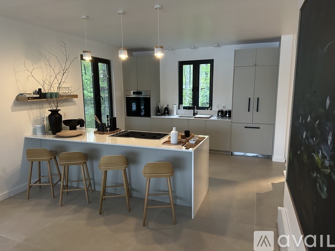A modern kitchen with a bar area and stools.
