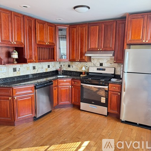 A kitchen with wooden cabinets and a stainless steel refrigerator.