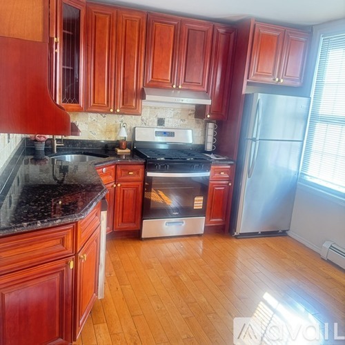 A kitchen with wooden cabinets and a black countertop.