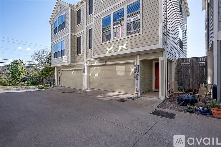 A two-story building with a garage and a driveway in front.
