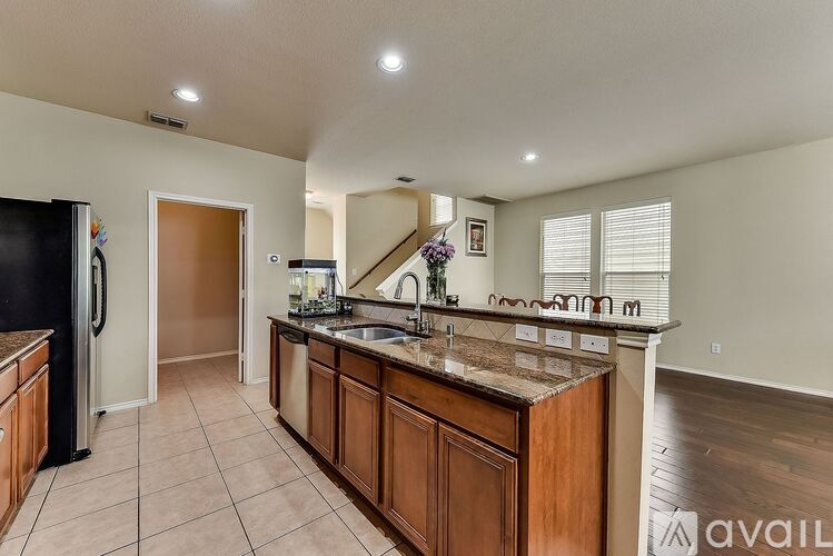 A kitchen with a black refrigerator and wooden cabinets.