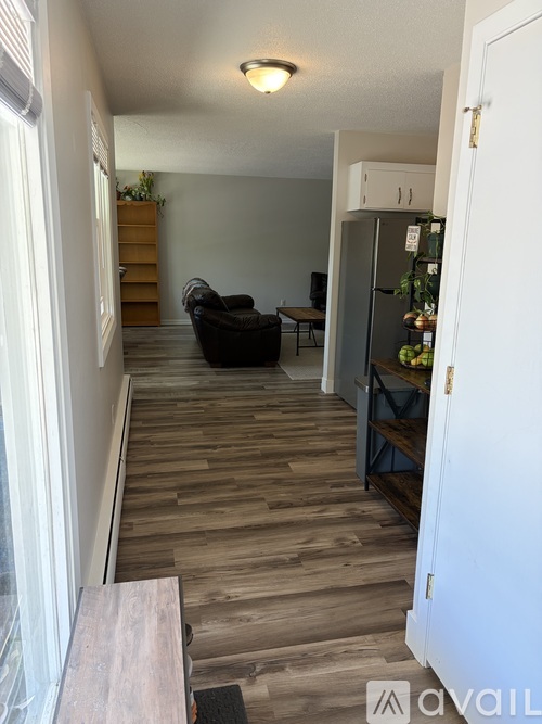A kitchen with a refrigerator and a dining table.