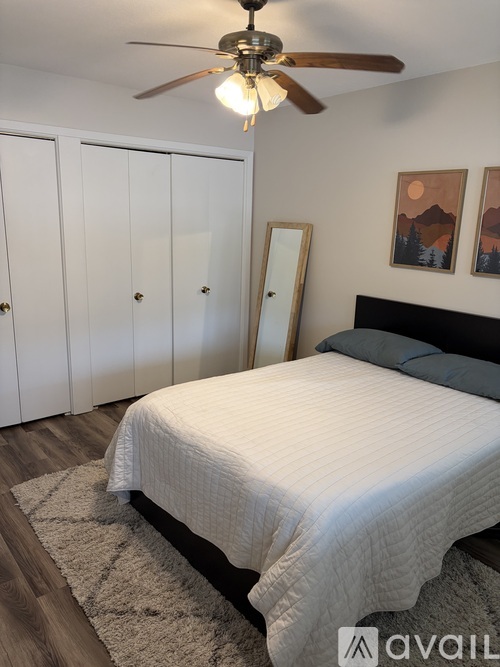 A bedroom with a bed, a ceiling fan, and a rug.