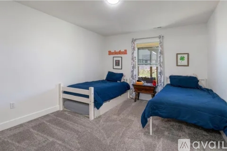 A bedroom with two beds and a window.