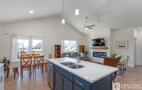 A kitchen with a large island and a dining table with chairs.