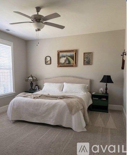 A bedroom with a large bed and a ceiling fan.