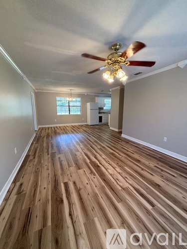 A room with wooden flooring and a ceiling fan.
