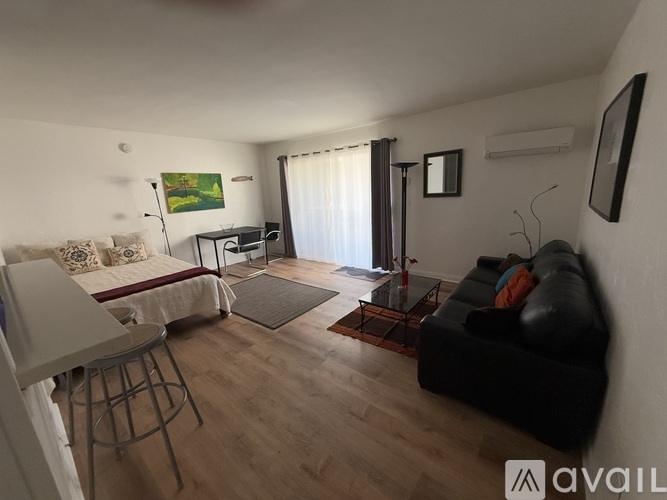 A living room with a couch, chair, and television.
