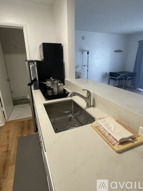 A kitchen with a sink and a microwave on the counter.