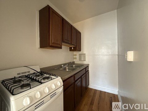 A kitchen with a white gas stove and wooden cabinets.