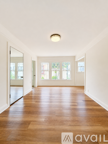 A hallway with wooden floors and white walls.