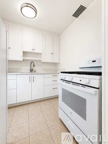 A white kitchen with a stove and cabinets.