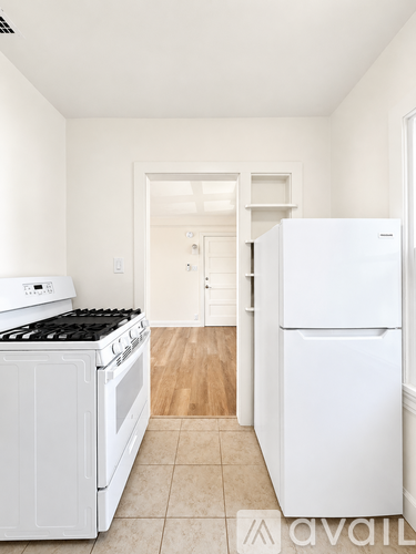 A kitchen with white appliances and a white fridge.