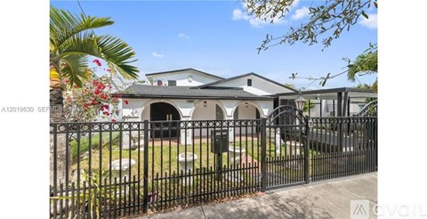 A white building with a black fence in front of it.