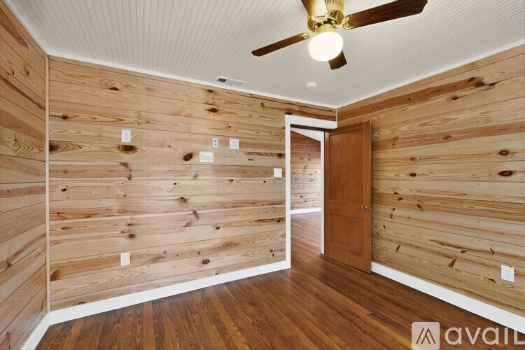 A room with wooden walls and a ceiling fan.