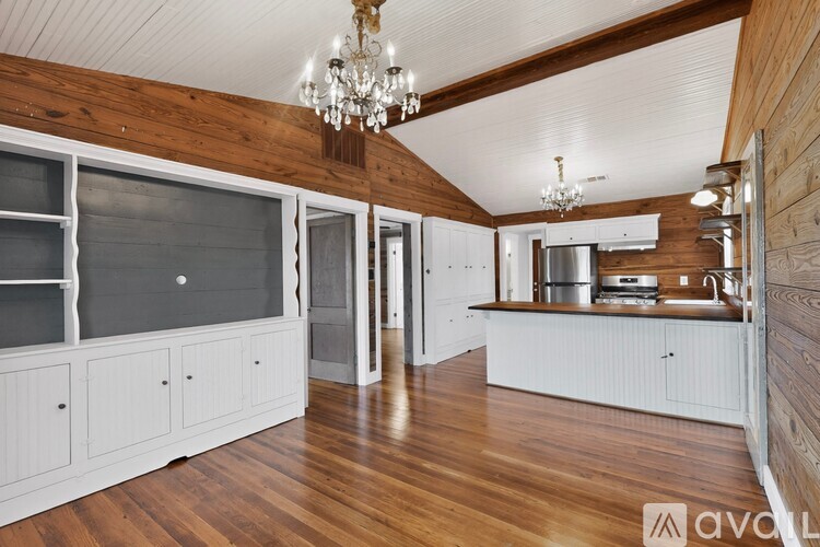 A kitchen with wooden floors and white cabinets.