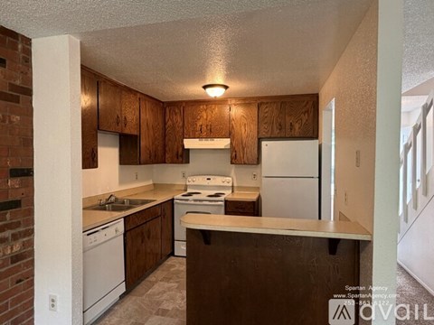 A kitchen with wooden cabinets and white appliances.