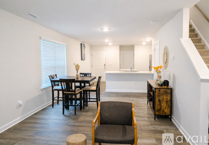 A dining room with a wooden table and chairs.