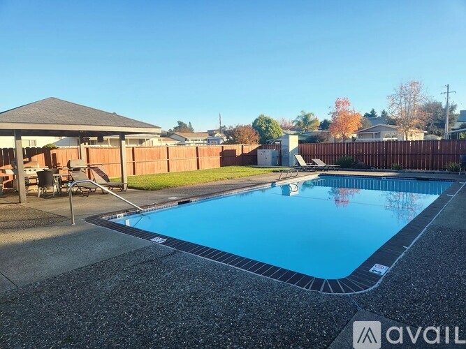A swimming pool surrounded by a fence and a gazebo.